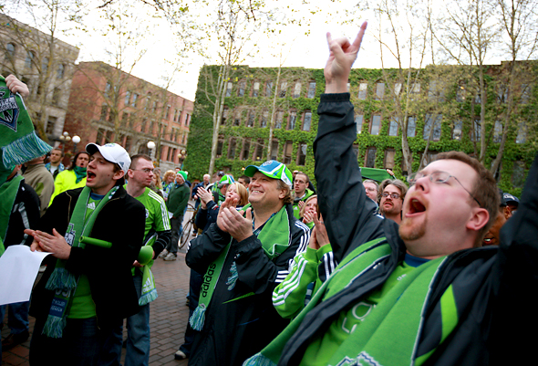 Drew Carey (center), rocks out with the fans as he listens to the Sounders' band at Occidental Park in Seattle. (Scott Eklund/Red Box Pictures)