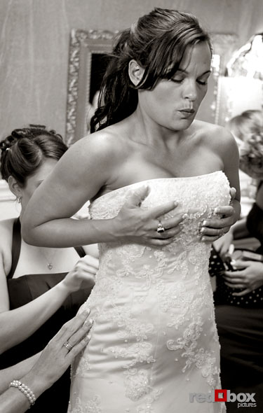 Michelle holding on as the corset on the back of her dress is laced up. (Photo By: Scott Eklund/Red Box Pictures)