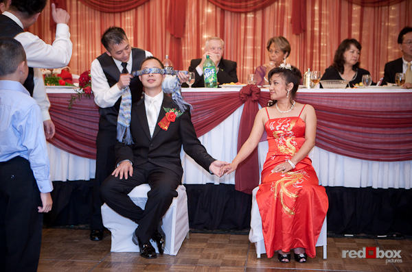 San gets blindfolded during a traditional ceremony at the reception. (Photo by Scott Eklund/Red Box Pictures)