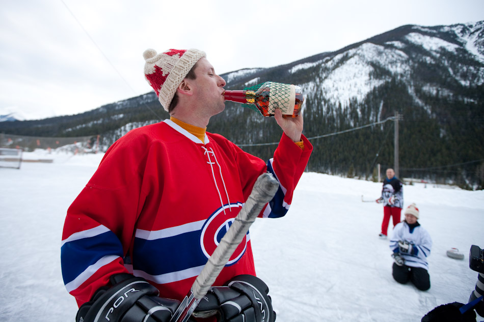 Steve takes a swig of Maker's Mark to help keep warm during an outdoor hockey game in Field, B.C. (Photography by Scott Eklund/Red Box Pictures)