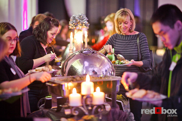 Guests serve themselves from a buffet prepared by A Grand Affaire Catering at "RE-New", their Winter Open House and Complimentary Tasting, the Engine Room in Georgetown Studios in Seattle. (Photo by Red Box Pictures)