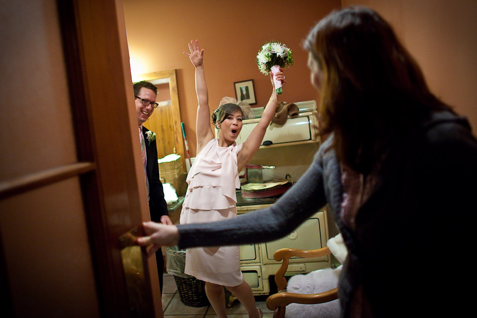 Karen lets out a cheer toward her wedding party from a bathroom just after being married at Emerald Lake Lodge in Yoho National Park, Canada. (Photo by Andy Rogers/Red Box Pictures)