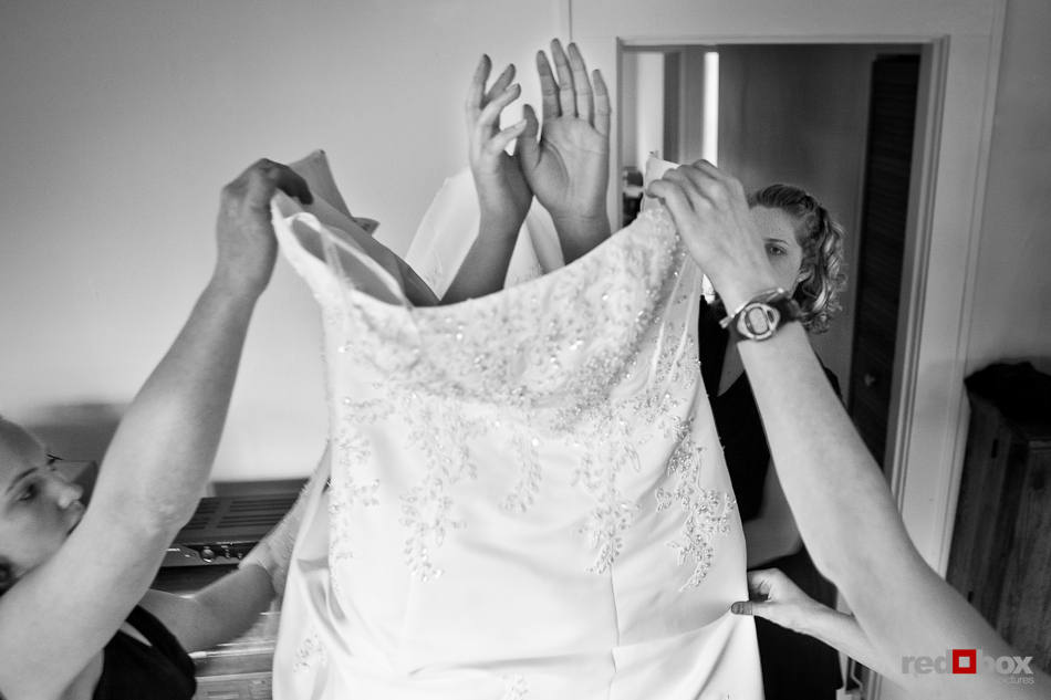 Merilee's bridesmaids help her put on her wedding dress at her home in Mt. Vernon, WA. (Photography by Andy Rogers/Red Box Pictures)