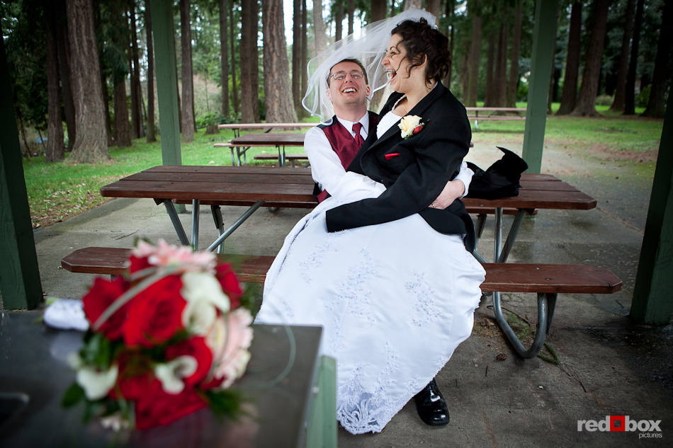 Merilee and Phil laugh as they sit alone at Hillcrest Park immediately after being married at Hillcrest Lodge in Mt. Vernon, WA. (Photography by Andy Rogers/Red Box Pictures)