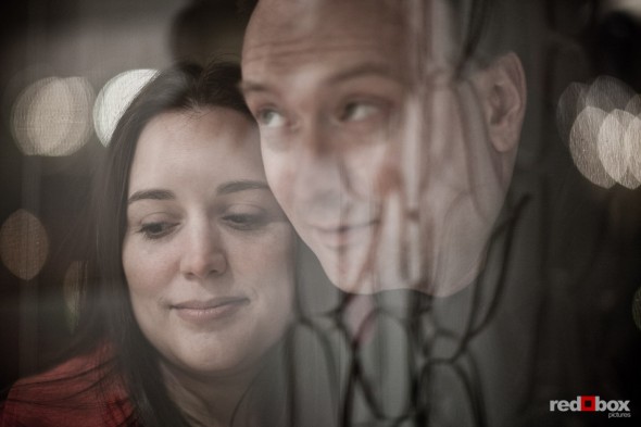Tara and Brian peer into a shop window in old Ballard during their engagement session. (Photography by Andy Rogers/Red Box Pictures)