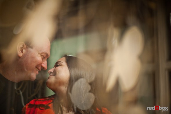 Ballard engagement photos of Tara and Brian next to a storefront window. (Photography by Andy Rogers/Red Box Pictures)