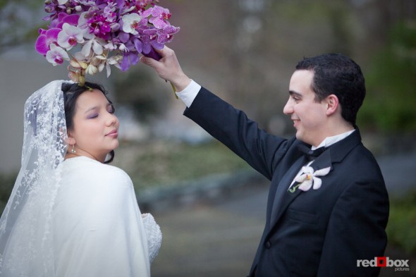 Kris keeps the rain off Sarah's head using her bouquet while taking portraits outside the Lake Union Cafe in Seattle. (Photo by Rob Sumner/Red Box Pictures)