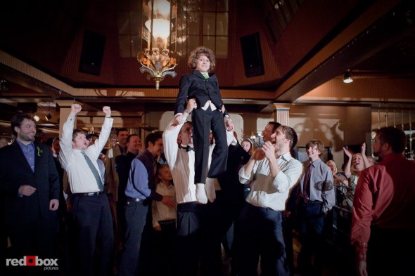 A boy is held aloft for praise after he catches the garter during a wedding at the Lake Union Cafe in Seattle. (Photo by Rob Sumner/Red Box Pictures)