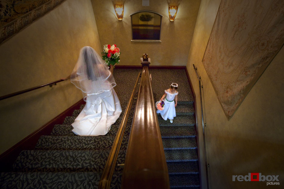 The bride and her daughter and flower girl walk down the stairs on their way to the wedding ceremony at the Golf Club at Newcastle near Seattle. (Wedding Photographer/Scott Eklund/Red Box Pictures)
