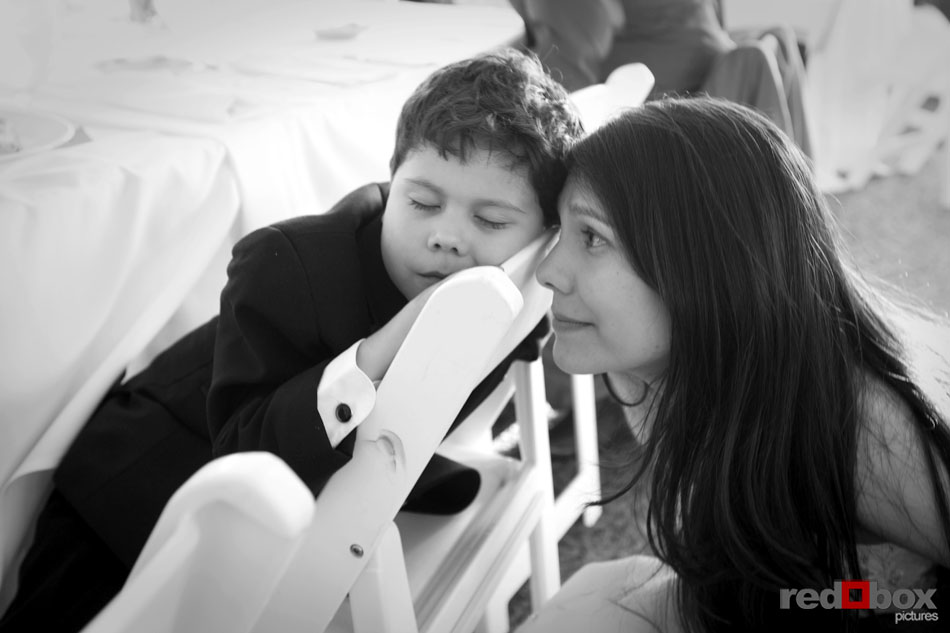 The bride looks at her son who fell asleep at the wedding reception. (Photography by Scott Eklund/Red Box Pictures)