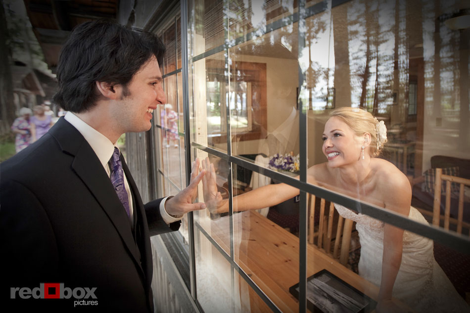 The bride and groom touch hands through the window at their wedding at Kitsap Memorial State Park. Red Box Pictures - Scott Eklund-Seattle Wedding Photographers