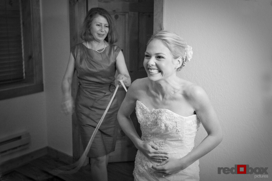 The bride smiles as she gets her dress on with her mom before the Kitsap Memorial State Park wedding. Seattle Wedding Photographers - Red Box Pictures - Scott Eklund