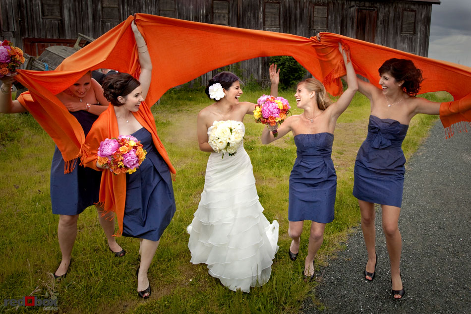The bride and bridesmaids cover up from the rain at Semiahmoo Resort in Blaine, WA. Seattle Wedding Photographer Scott Eklund Red Box Pictures