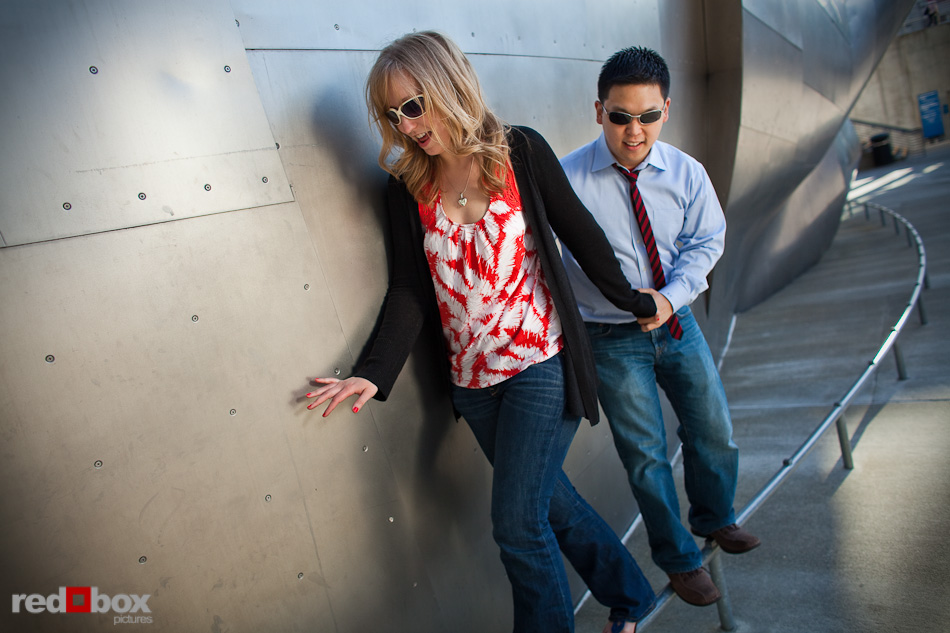 Jenny and Eugene balance on a rail outside the Experience Music Project (EMP) during their engagement session at Seattle Center Friday, June 11, 2010. (Photo by Andy Rogers/Red Box Pictures)