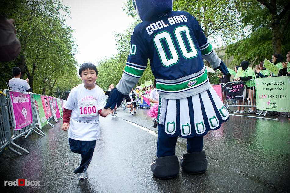 The child gets five from the Thunderbirds Cool Bird as he crosses the finish line during the kids race portion of the 2010 Susan G. Komen Race for the Cure in Seattle on June 6, 2010. (Photography by Andy Rogers/Red Box Pictures)