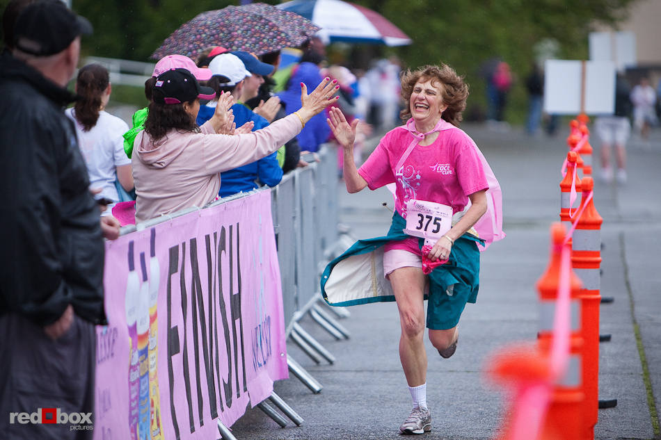 A breast cancer survivor celebrates with spectators as she approaches the finish line at the 2010 Susan G. Komen Race for the Cure in Seattle on June 6, 2010. (Photography by Andy Rogers/Red Box Pictures)