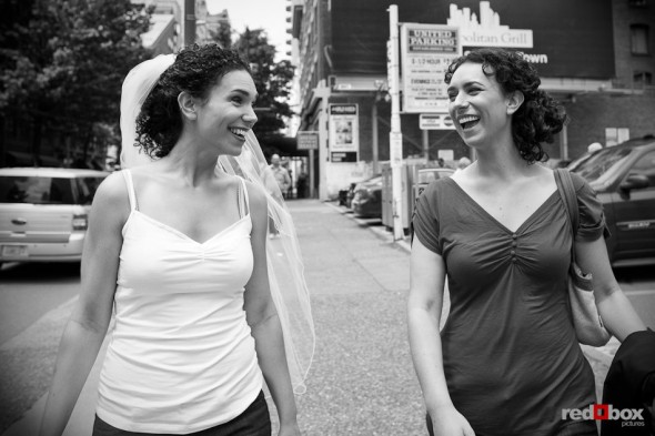 Bride Laura walks with her sister in downtown Seattle before her wedding to Nathan at the Novelty Hill Januik Winery in Seattle. (Photo by Dan DeLong/Red Box Pictures)