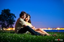 At dusk, Anghi and Andy pose with the glow of West Seattle behind them during an engagement portrait session at Myrtle Edwards Park. Photo by Dan DeLong/Red Box Pictures