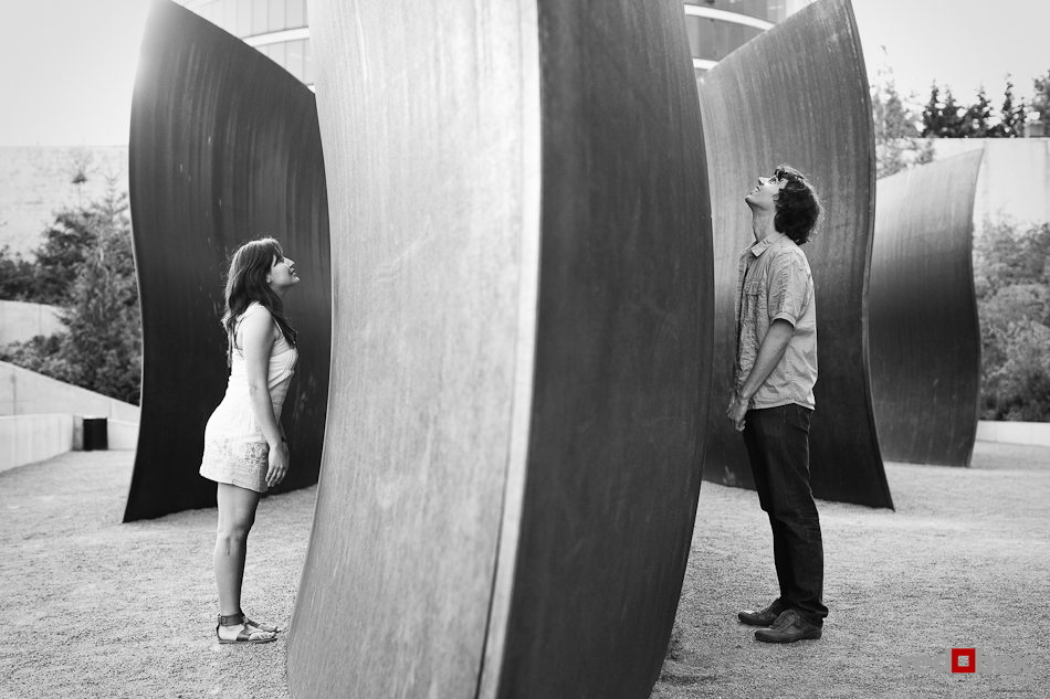 Anghi and Andy play amidst the art at Seattle Art Museum Sculpture Park while being photographed for their engagement. Photo by Dan DeLong/Red Box Pictures
