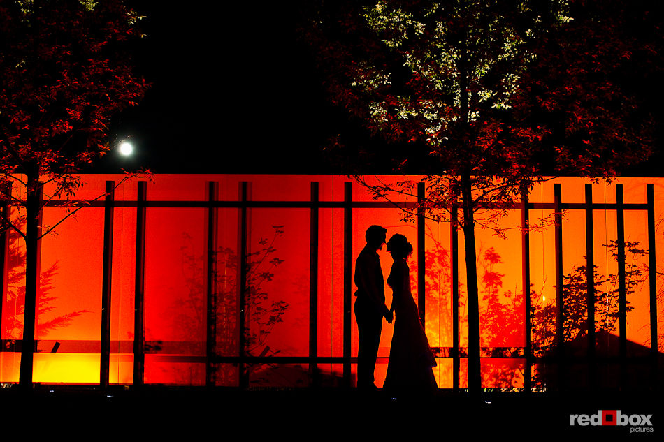Laura and Nathan kiss with the moon above them during their wedding the Novelty Hill Januik Winery in Woodinville, WA. (Photo by Dan DeLong/Red Box Pictures)