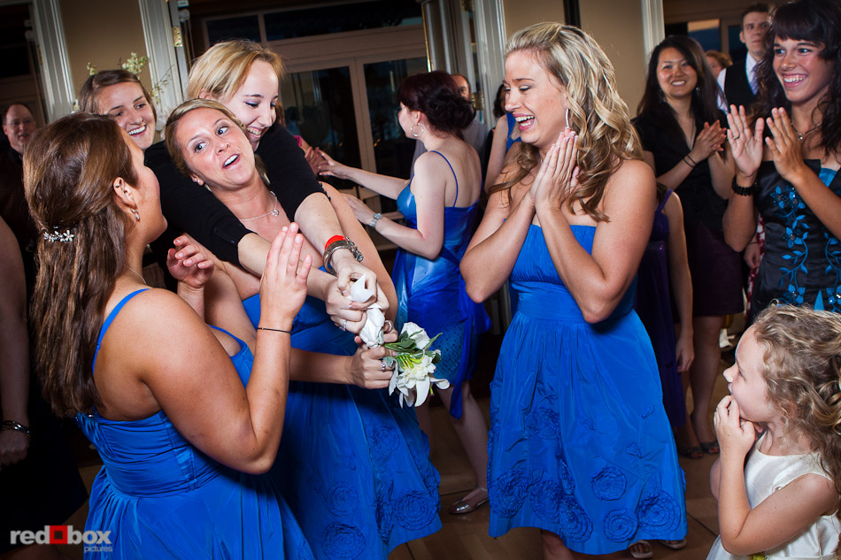 Rachel's bridesmaids ang guests dispute the victory in the bouquet toss during the wedding reception at the Woodmark Hotel in Kirkland, WA. (Photography by Andy Rogers/Red Box Pictures)
