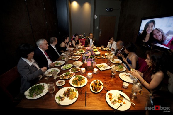Johanna & Neel and their families watch a slide show during dinner at Wild Ginger in Bellevue. (Seattle Wedding Photographer Scott Eklund Red Box Pictures)