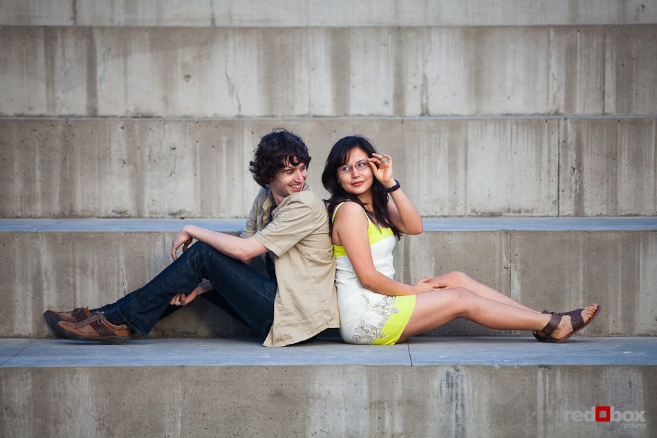 Anghi and Andy pose on steps during their engagement portrait session at Seattle Art Museum Sculpture Park. Photo by Dan DeLong/Red Box Pictures