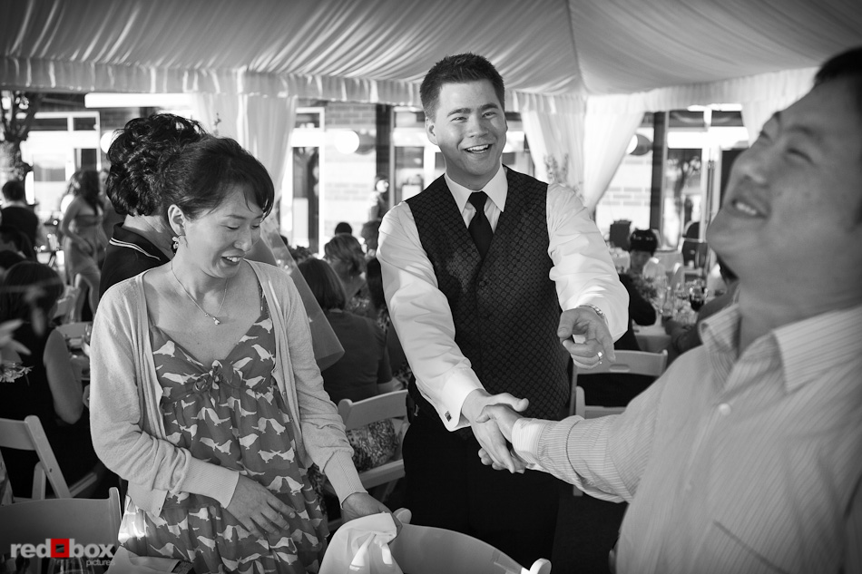 Shawn greets wedding guests during dinner in the tent at the Woodmark Hotel in Kirkland, WA. (Photography by Andy Rogers/Red Box Pictures)