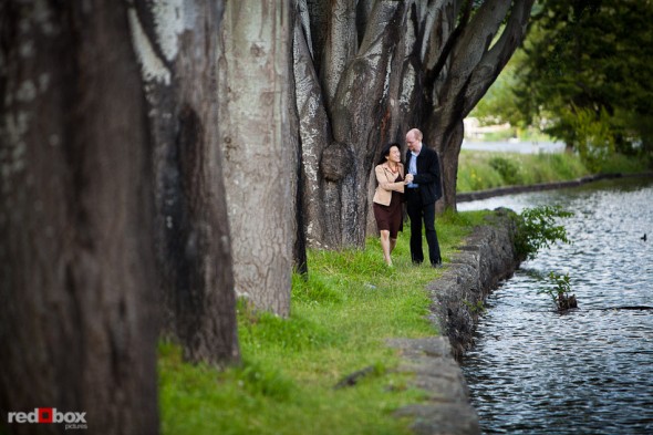 Nobuyo and Rory among the trees next to Lake Washington during their engagement portrait session at Seward Park in Seattle. (Photography by Andy Rogers/Red Box Pictures)