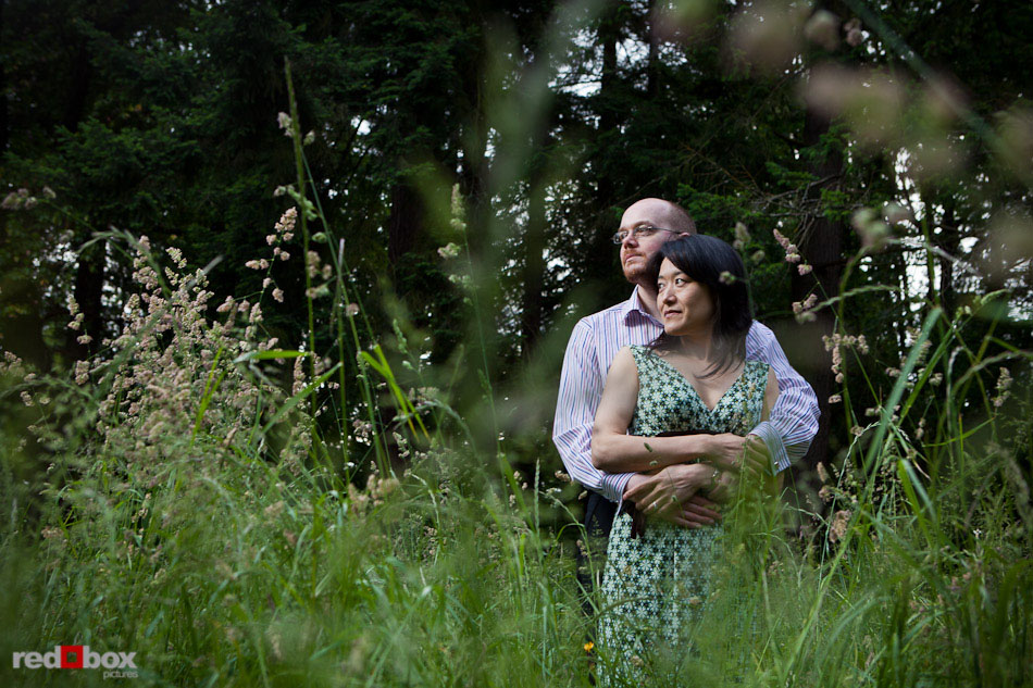 Nobuyo and Rory among the tall grass during their engagement portrait session at Seward Park in Seattle. (Photography by Andy Rogers/Red Box Pictures)