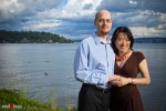 Nobuyo and Rory stand next to Lake Washington during their engagement portrait session at Seward Park in Seattle. (Photography by Andy Rogers/Red Box Pictures)