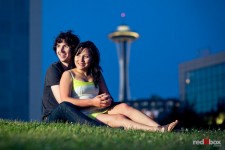The Space Needle looms behind Anghi and Andy during their engagement photo shoot at Seattle's Myrtle Edwards Park. Photo by Dan DeLong/Red Box Pictures