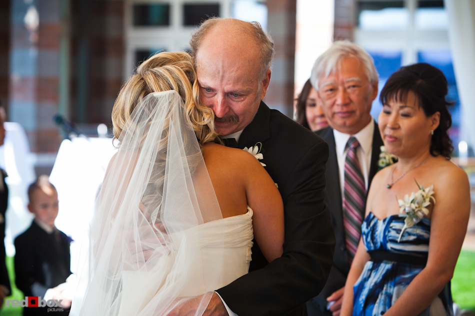 Rachel gets a heartfelt hug from her father after walking down the aisle during her wedding ceremony at the Woodmark Hotel in Kirkland, WA. (Photography by Andy Rogers/Red Box Pictures)