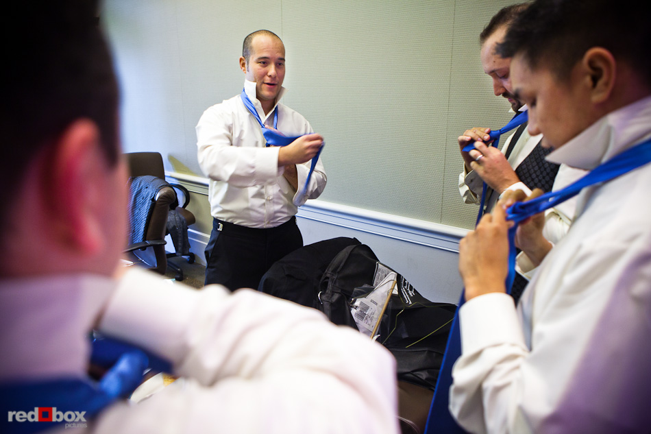 Shawn's groomsmen give and get instruction on how to tie their ties prior to his wedding ceremony at the Woodmark Hotel in Kirkland, WA. (Photography by Andy Rogers/Red Box Pictures)