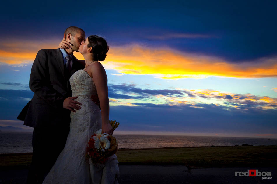 Bride and groom kiss at sunset at Fort Casey State Park on Whidbey Island, Wash. (Wedding Photography Scott Eklund Red Box Pictures Seattle)