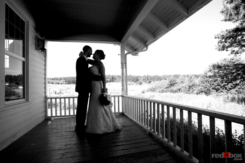 Bride and groom kiss on the porch at Greenbank Farms on Whidbey Island, Wash. (Wedding Photography Scott Eklund Red Box Pictures Seattle)