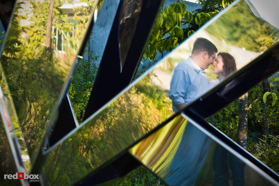 At the Seattle Art Museum's Olympic Sculpture Park, Katherine and Bryan are reflected in a sculpture during engagement photo session. (Photo by Dan DeLong/Red Box Pictures)