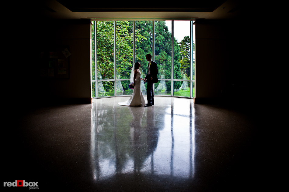 Emily and Will stand by a window in the Seattle Asian Art Museum prior to their Volunteer Park wedding in Seattle. (Photo by Andy Rogers/Red Box Pictures)