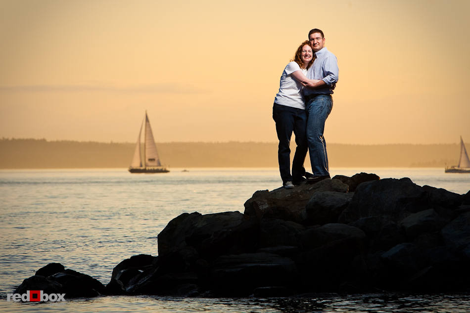 The sun sets over Puget Sound behind Katherine and Bryan during their engagement session at Myrtle Edwards Park in Seattle. (Photo by Dan DeLong/Red Box Pictures)