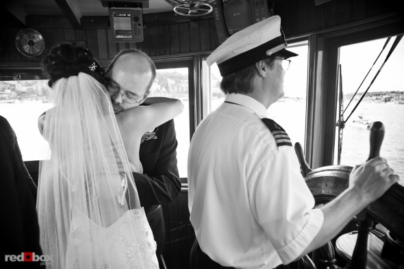 Nobuyo and Rory embrace in the pilot house following their wedding ceremony aboard the Virginia V on Lake Union in Seattle. Photo by Seattle wedding photographer Andy Rogers of Red Box Pictures.