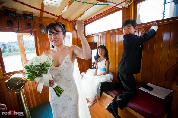 Nobuyo pulls the rope to trigger the Virginia V's steam whistle as the ship disembarks prior to her wedding ceremony and recpetion. Photo by Seattle wedding photographer Andy Rogers of Red Box Pictures.