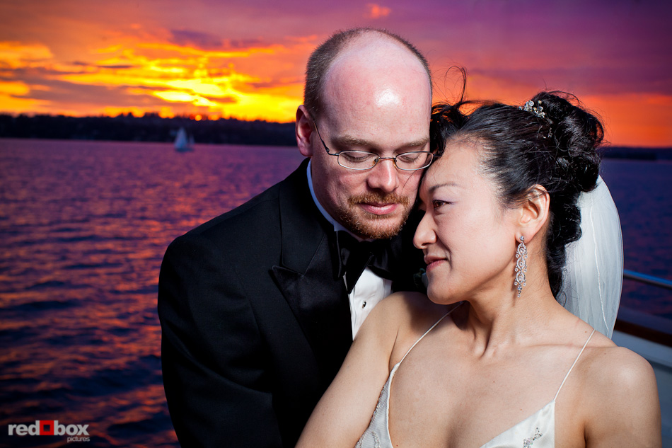 Nobuyo and Rory enjoy a beautiful sunset on Lake Washington during their wedding reception aboard the Virginia V in Seattle. Photo by Seattle wedding photographer Andy Rogers of Red Box Pictures.