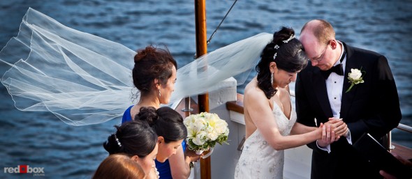 Nobuyo and Rory bow their heads in prayer during their wedding ceremony aboard the Virginia V on Lake Union in Seattle. Photo by Seattle wedding photographer Andy Rogers of Red Box Pictures.