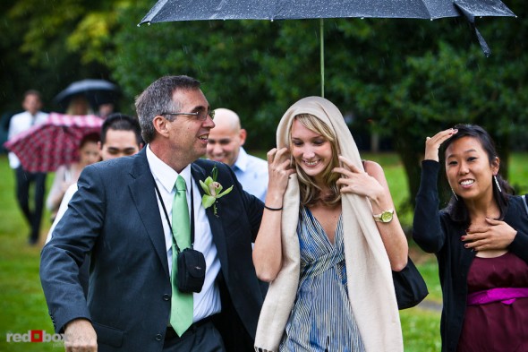 Guests are escorted with an umbrella upon arriving for Emily and Will's Volunteer Park wedding in Seattle. (Photo by Andy Rogers/Red Box Pictures)
