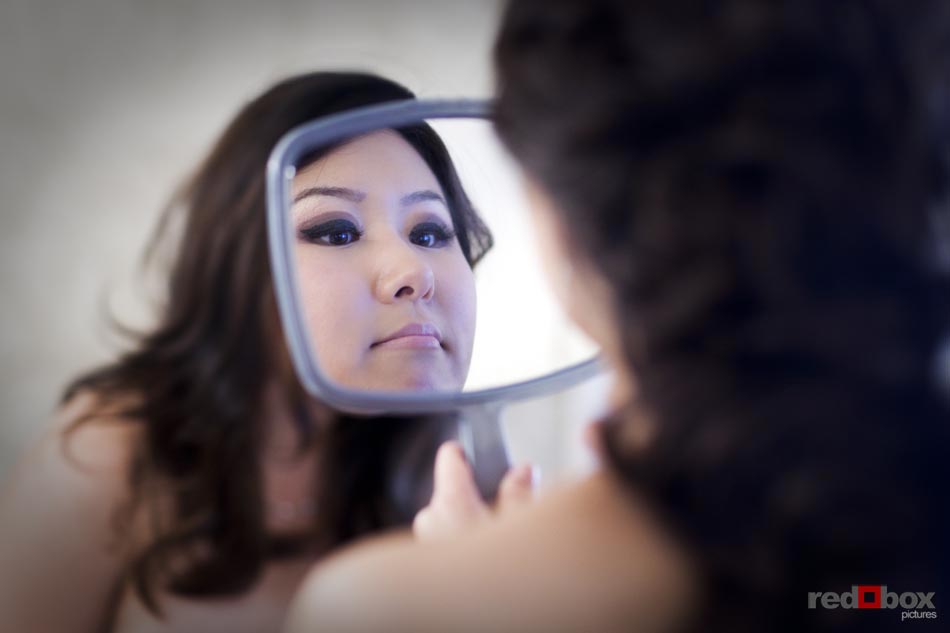 The bride checks out her makeup in the mirror before her wedding at Inglewood Golf Club in Kenmore, Washington. ( Wedding photography by Scott Eklund/Red Box Pictures/Seattle)