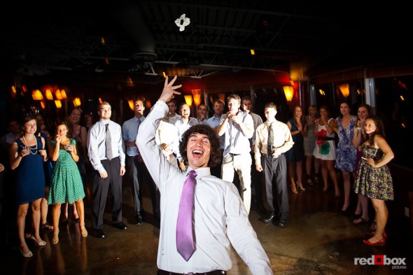 Andy tosses Anghi's garter during their wedding reception at The Canal in Seattle. (Photo by Dan DeLong/Red Box Pictures)