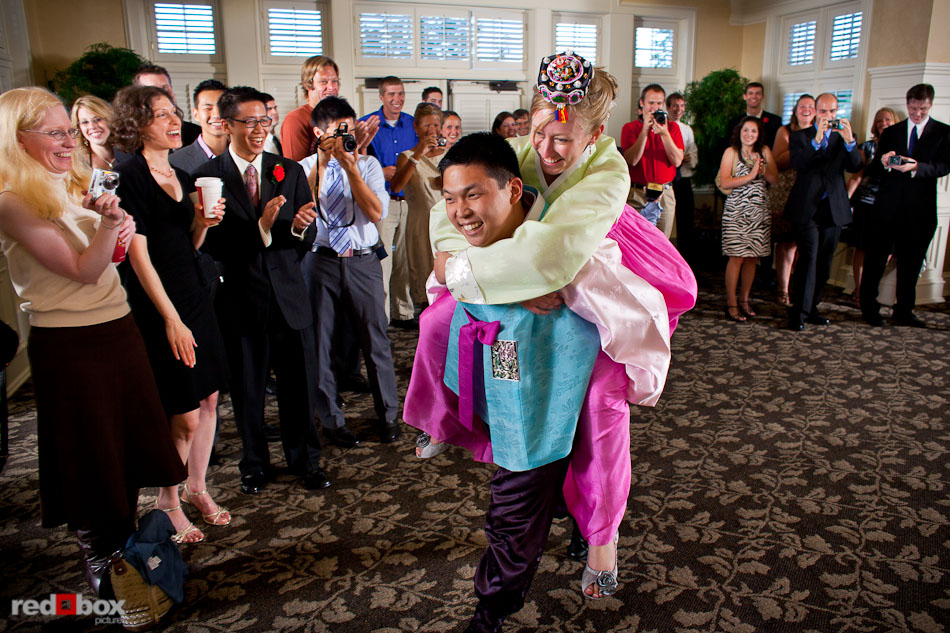Eugene carries Jenny on his back at the conclusion of their Korean tea ceremony during their wedding at The Golf Club at Newcastle. (Photo by Andy Rogers/Red Box Pictures)