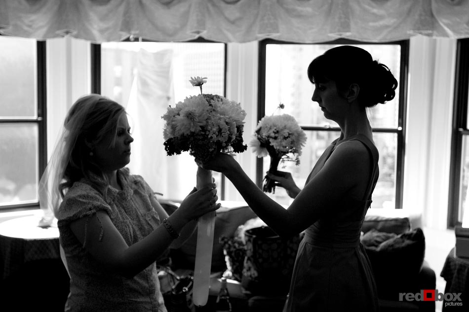 The bride and her bridesmaid work on her bouquet at the Sorrento Hotel before they head to the wedding at The Hall at Fauntleroy in West Seattle, Washington. (Wedding Photography By Scott Eklund Red Box Pictures Seattle)