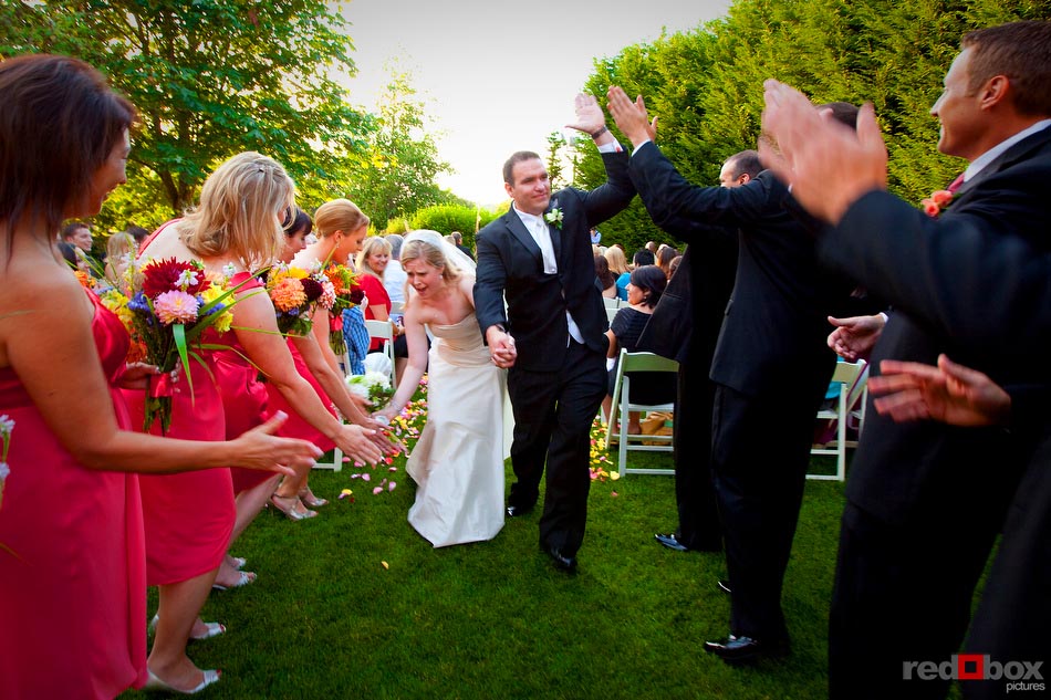 The bride and groom get high and low fives from their bridal party following their wedding at The Hall at Fauntleroy in Seattle, Washington. Seattle Wedding Photographer Red Box Pictures Scott Eklund