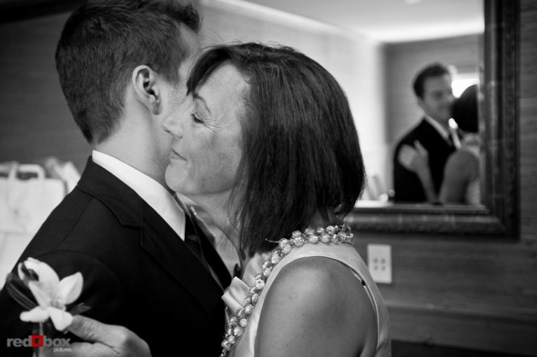 Alex's mother pins on his boutonniere prior to his wedding at the Edgewater Hotel. (Photo by Andy Rogers/Red Box Pictures)
